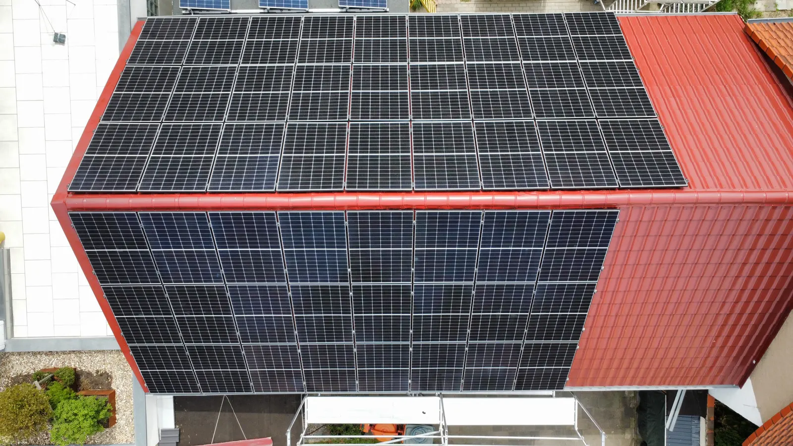Photovoltaics on the roof and canopy of a house with a red metal roof