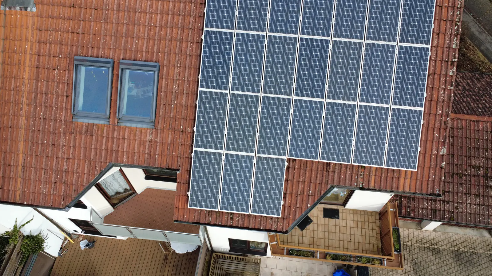 Photovoltaic modules on a tiled roof with a roof window